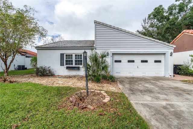 view of front of property with a front yard, central AC unit, and a garage