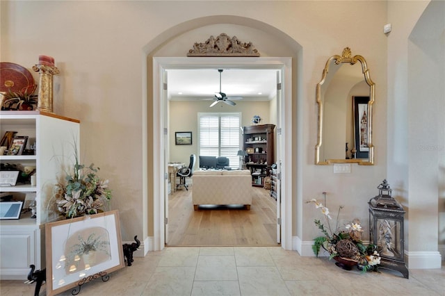 hallway with crown molding and light wood-type flooring