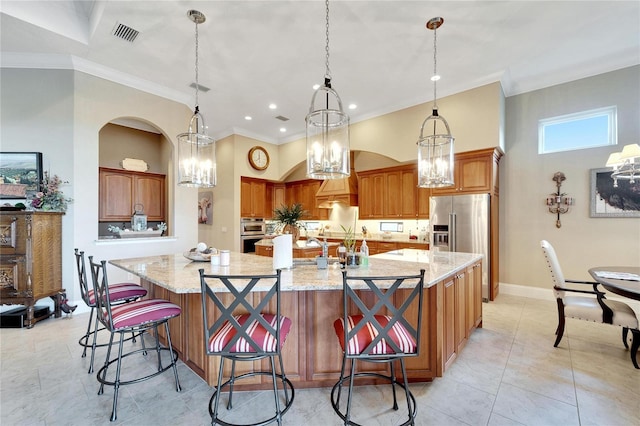 kitchen with appliances with stainless steel finishes, a spacious island, a kitchen breakfast bar, pendant lighting, and crown molding