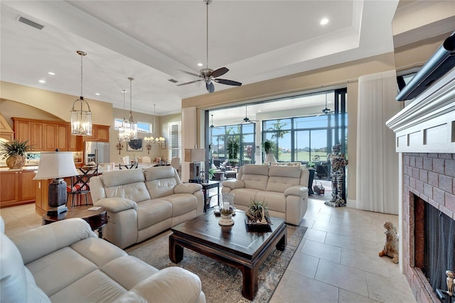 tiled living room with ceiling fan and a brick fireplace