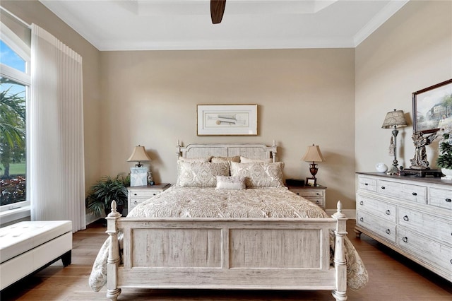 bedroom featuring crown molding, dark hardwood / wood-style floors, and ceiling fan