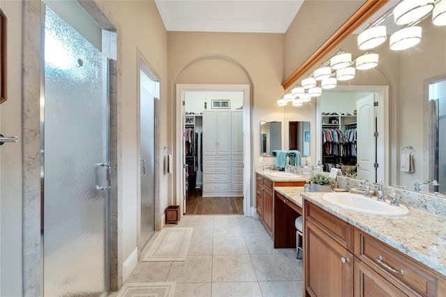 bathroom with vanity, crown molding, a shower with shower door, and tile patterned flooring