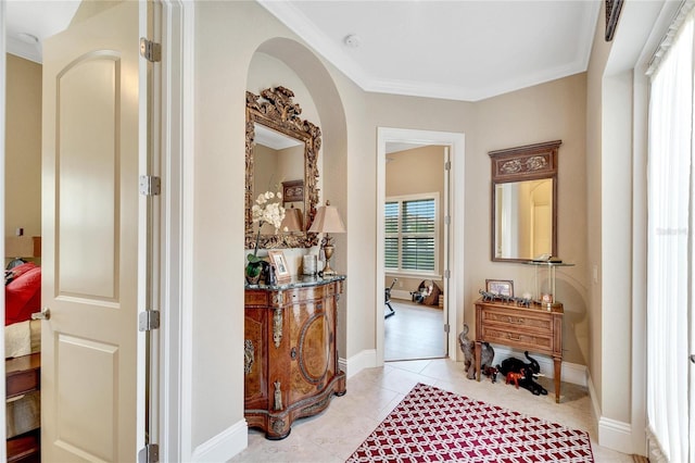 corridor featuring ornamental molding and light tile patterned floors