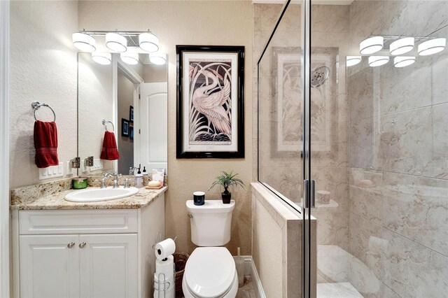 bathroom featuring vanity, toilet, and a shower with door