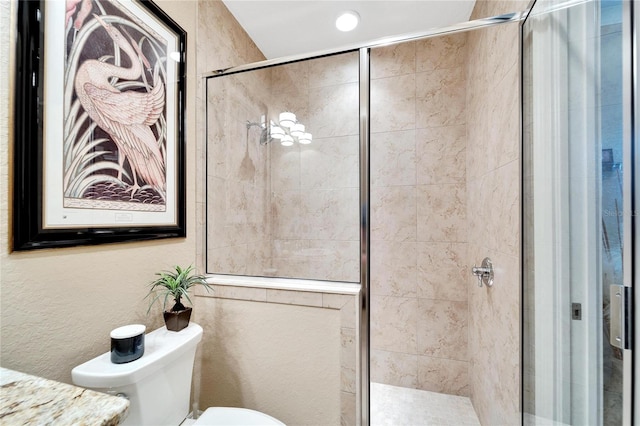 bathroom featuring toilet and a shower with door