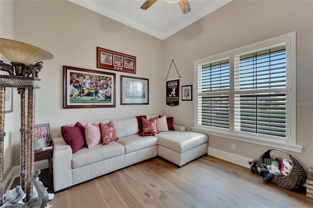 living room featuring ceiling fan, crown molding, and light hardwood / wood-style flooring