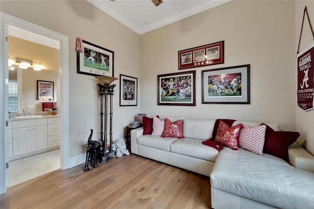 living room featuring light hardwood / wood-style flooring, ornamental molding, sink, and ceiling fan