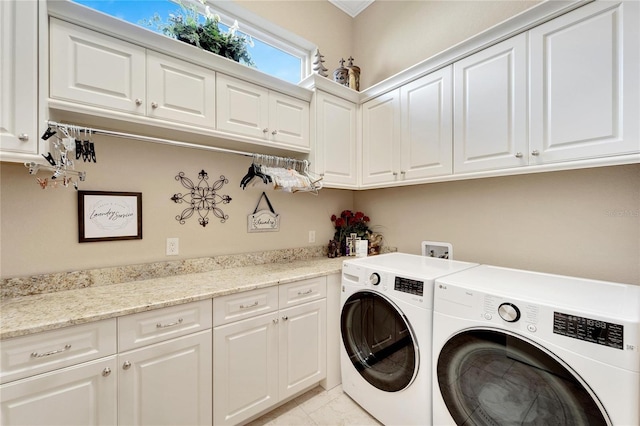 laundry room with washer and clothes dryer and cabinets