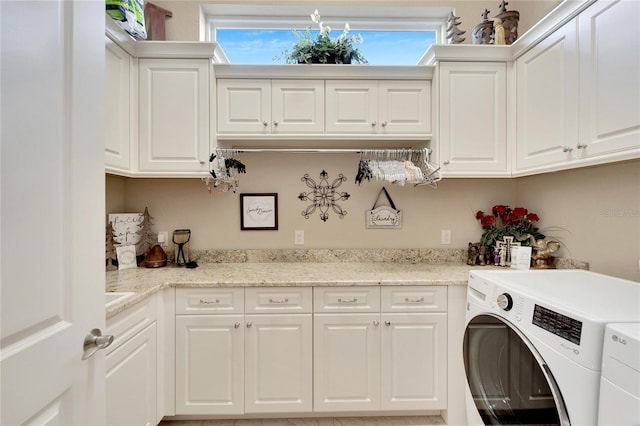 washroom with washing machine and dryer and cabinets