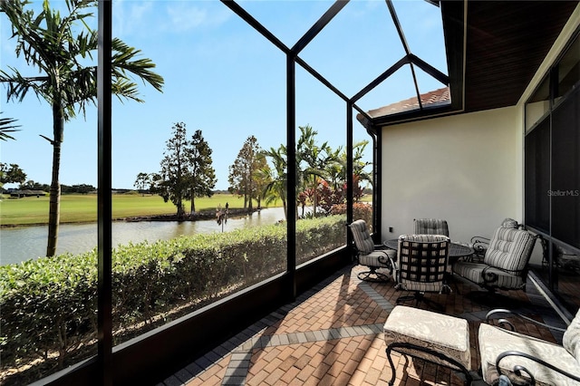 sunroom featuring a water view