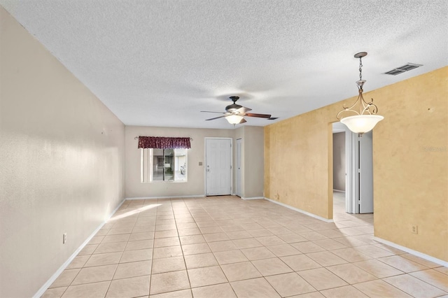 tiled empty room featuring ceiling fan and a textured ceiling