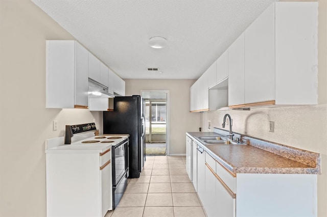 kitchen with sink, white range with electric cooktop, light tile patterned floors, white cabinets, and a textured ceiling