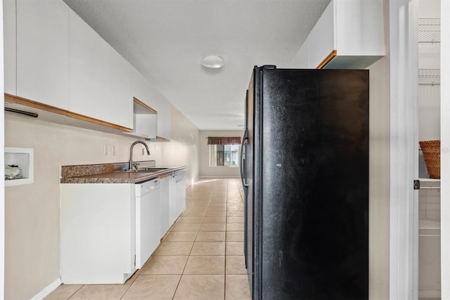 kitchen with white cabinetry, dishwasher, sink, and black refrigerator