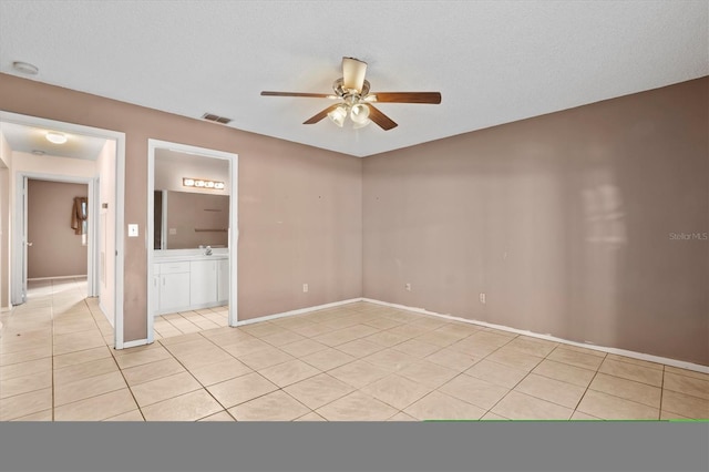 tiled spare room with ceiling fan and a textured ceiling