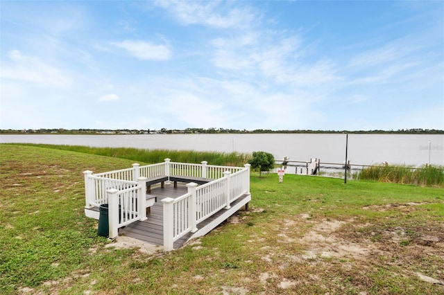 dock area with a yard and a water view