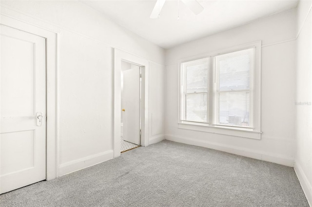 carpeted spare room with ceiling fan