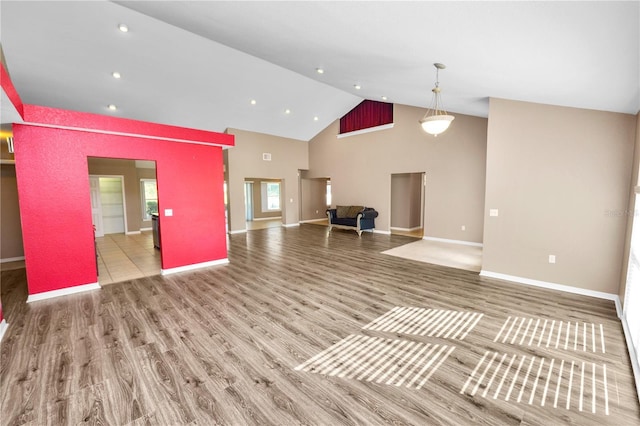 unfurnished living room featuring hardwood / wood-style flooring and high vaulted ceiling