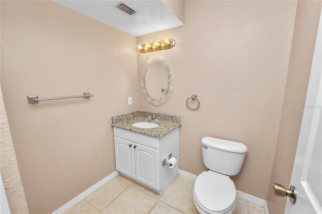 bathroom featuring tile patterned flooring, vanity, and toilet