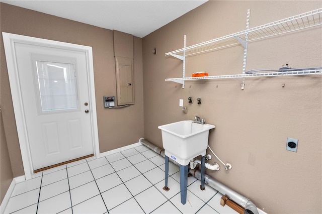 washroom featuring light tile patterned floors, electric panel, electric dryer hookup, and sink