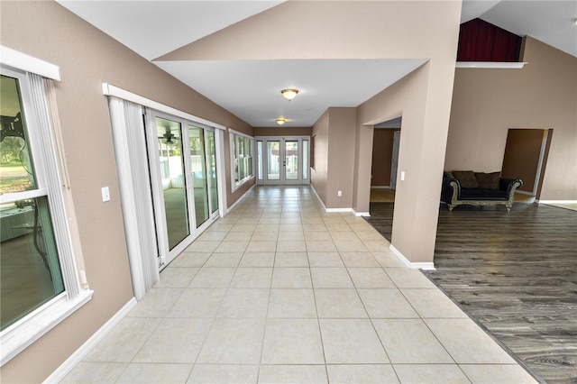 corridor featuring light hardwood / wood-style floors and lofted ceiling