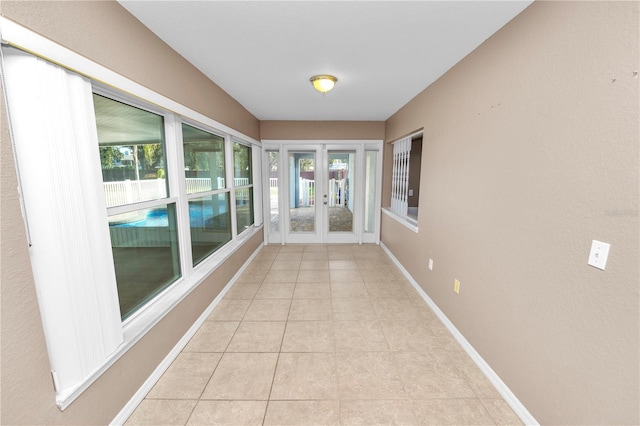 hall featuring french doors and light tile patterned flooring