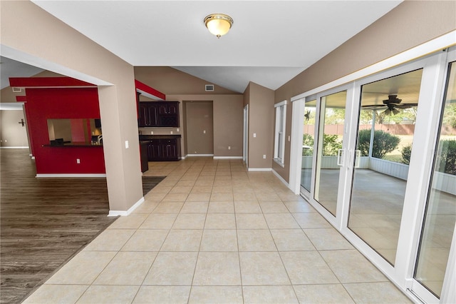 interior space featuring light tile patterned floors, ceiling fan, and lofted ceiling