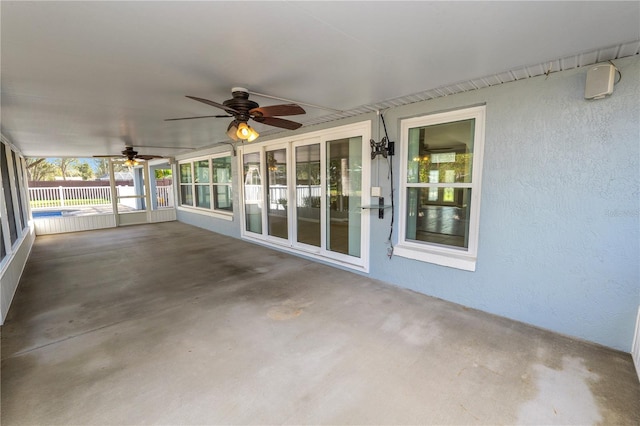 unfurnished sunroom with ceiling fan