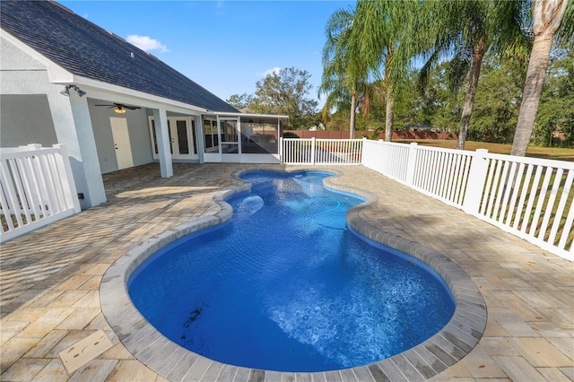 view of swimming pool with a sunroom, ceiling fan, and a patio area