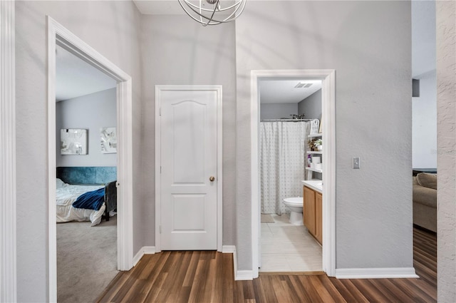 hallway featuring a notable chandelier and dark hardwood / wood-style floors