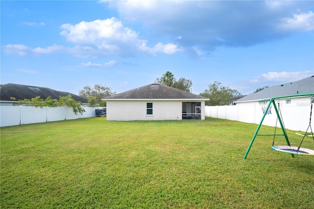 rear view of property featuring a lawn and a sunroom