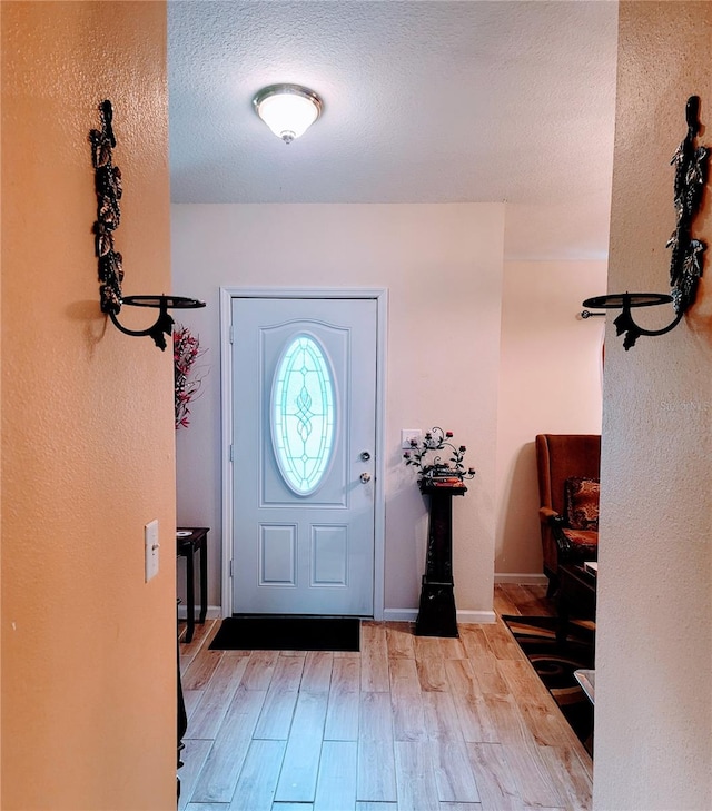 entrance foyer with light hardwood / wood-style flooring and a textured ceiling