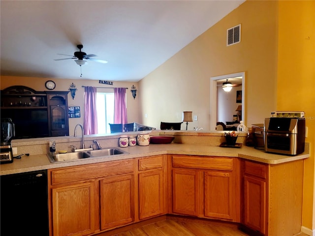 kitchen with black dishwasher, sink, ceiling fan, lofted ceiling, and light hardwood / wood-style flooring