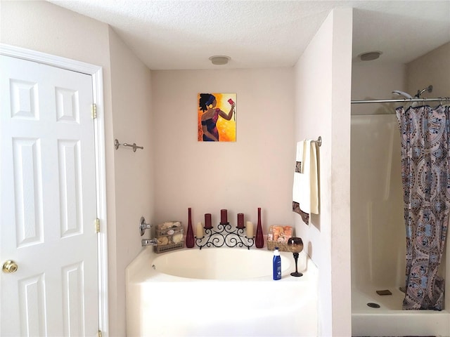 bathroom with a textured ceiling and independent shower and bath