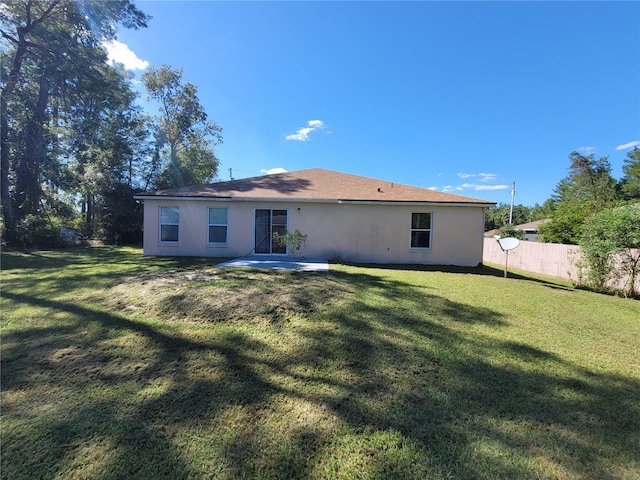 rear view of property featuring a lawn