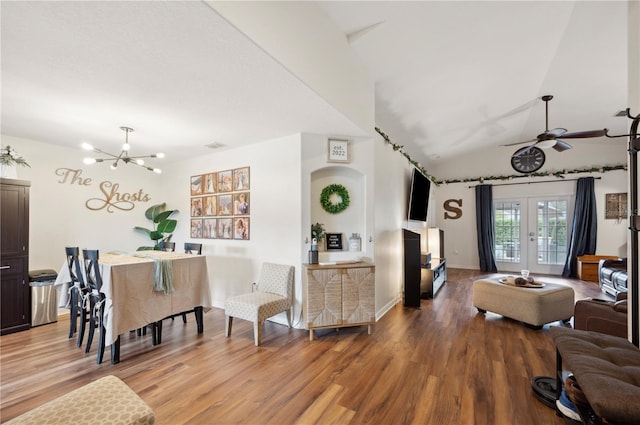 living room with lofted ceiling, hardwood / wood-style floors, ceiling fan with notable chandelier, and french doors