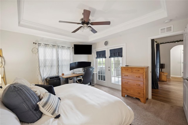 carpeted bedroom featuring access to outside, french doors, crown molding, a tray ceiling, and ceiling fan