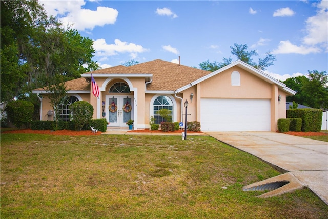 view of front facade featuring a garage, a front yard, and french doors