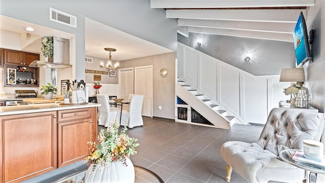 living room featuring vaulted ceiling with beams, a notable chandelier, and dark tile patterned floors