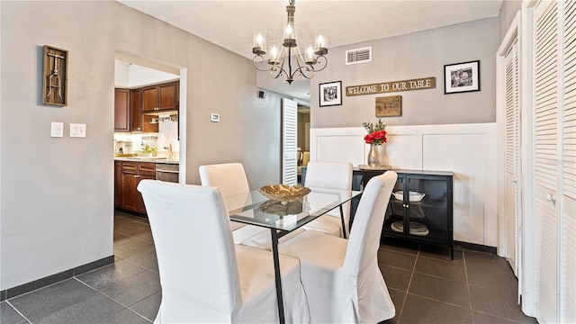 tiled dining space featuring sink and a notable chandelier