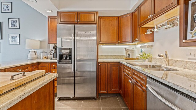 kitchen featuring light stone countertops, tile patterned floors, sink, and appliances with stainless steel finishes