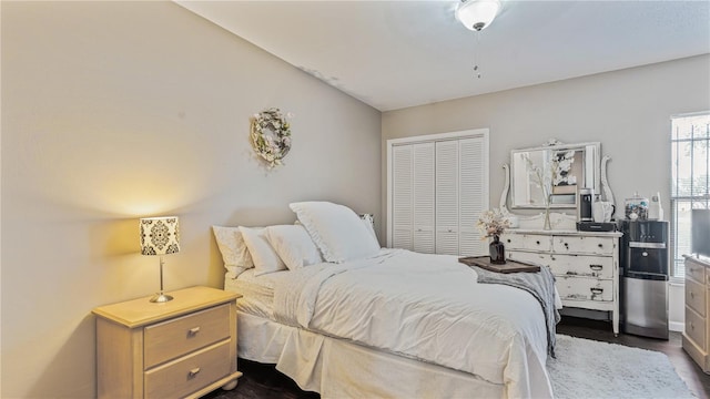 bedroom with dark hardwood / wood-style flooring, a closet, and lofted ceiling