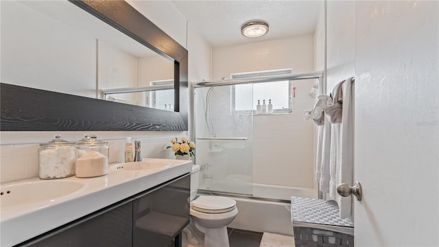 full bathroom featuring toilet, vanity, and shower / bath combination with glass door