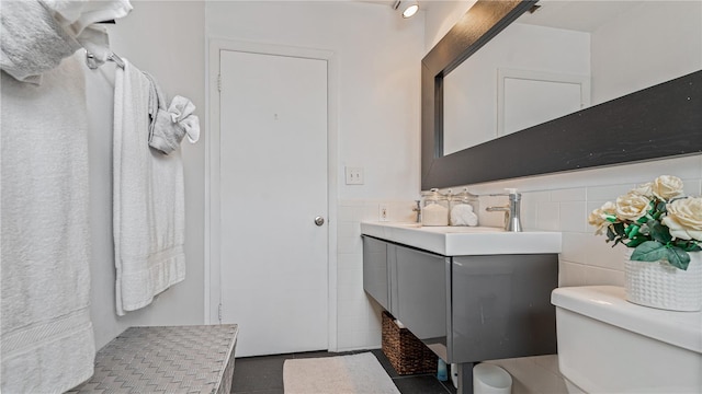 bathroom featuring toilet, vanity, tile walls, and tile patterned floors