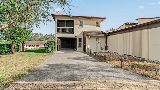 view of front of property with a carport and a front lawn