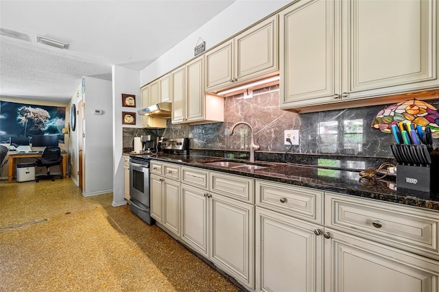 kitchen featuring dark stone counters, a textured ceiling, sink, electric range, and cream cabinetry