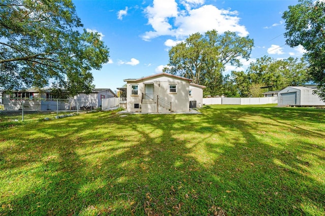 back of property with a garage, a lawn, and an outdoor structure