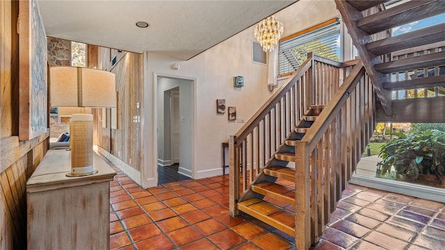 stairs featuring a notable chandelier