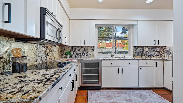 kitchen with wine cooler, sink, and white cabinets