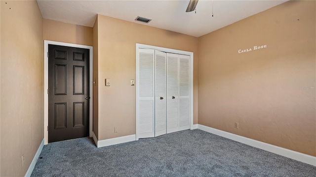 unfurnished bedroom featuring ceiling fan, dark carpet, and a closet