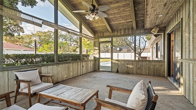 sunroom with plenty of natural light, lofted ceiling with beams, wood ceiling, and ceiling fan